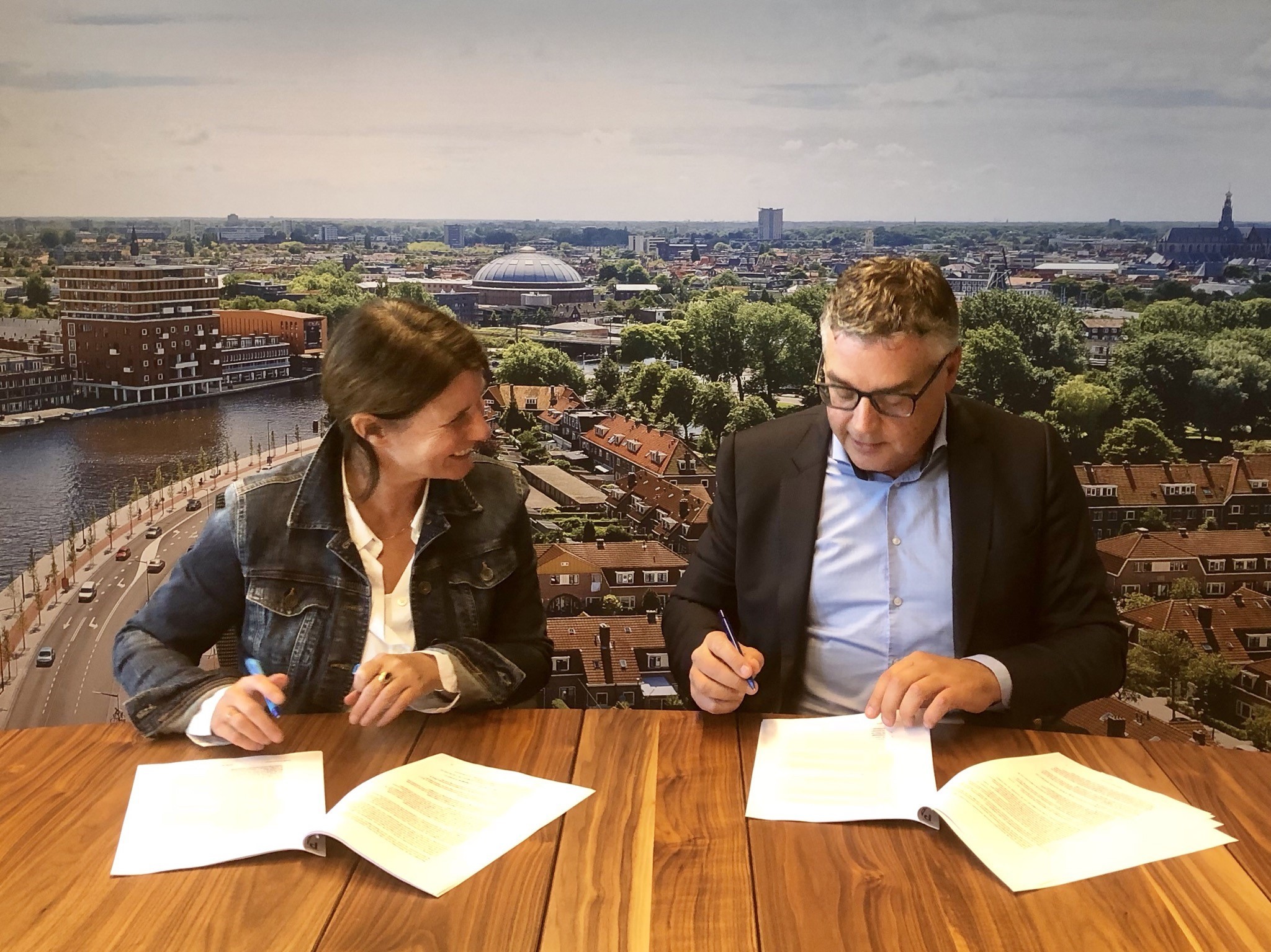 ré Wonen bestuurder Anke Huntjes en KBM-directeur Dick van der Plas zetten handtekening over project Staalstraat/De Bazellaan